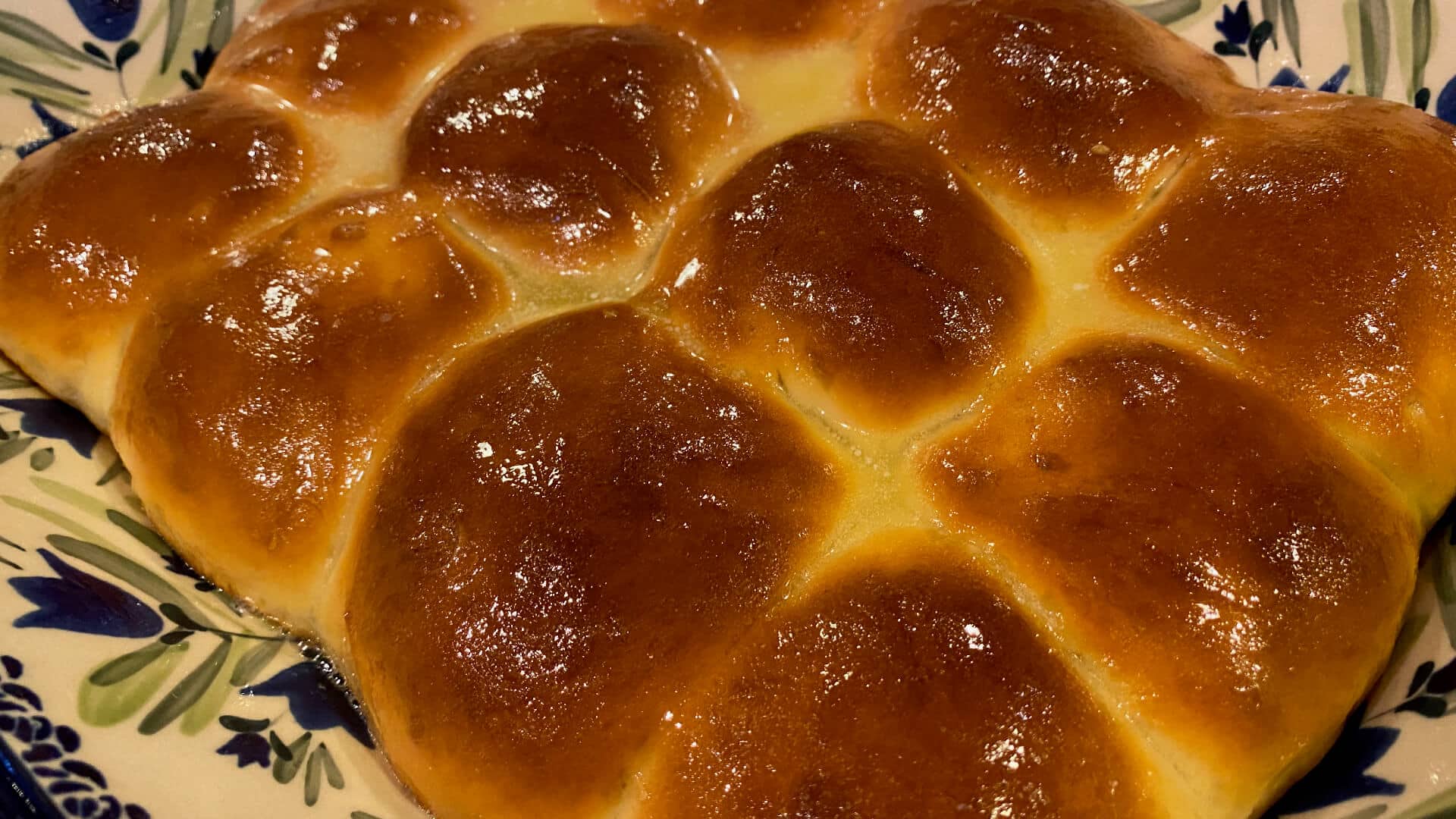 A plate of golden, glistening sourdough rolls